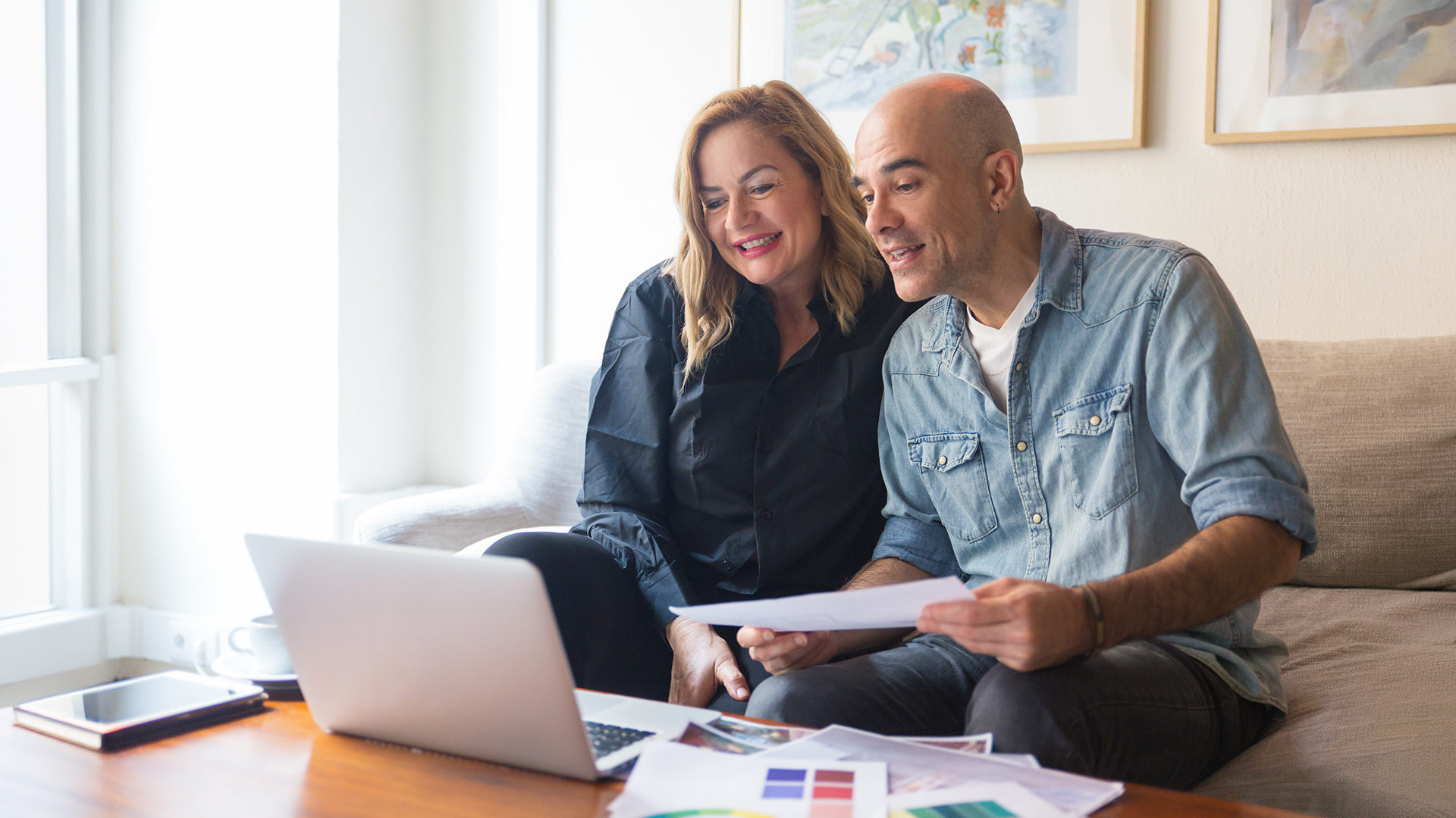 Couple smiling having a video call with their financial advisor.