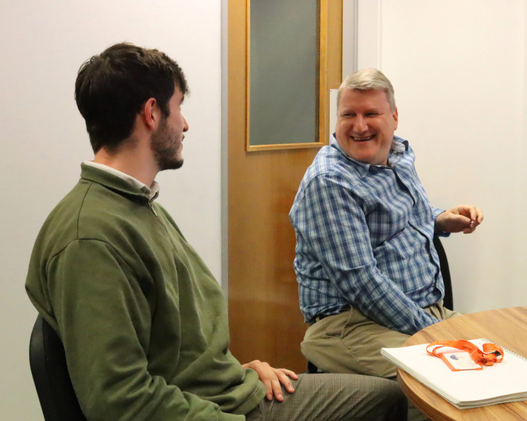 Client smiling at one of Reeves' financial advisors.