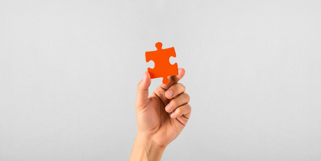 Hand holding a jigsaw piece.