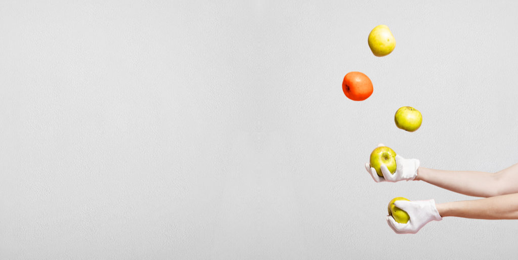 Hands juggling apples